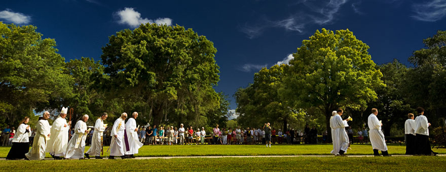 Priests of the Diocese of St. Petersburg process to Calvary's outdoor altar during Memorial Day Mass at the cemetery.