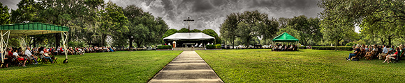 Dark clouds from the remnants of Tropical Storm Beryl loom over Memorial Day Mass at Calvary Catholic Cemetery. Rain did not dampen the annual Mass where nearly 400 faithful were in attendance.