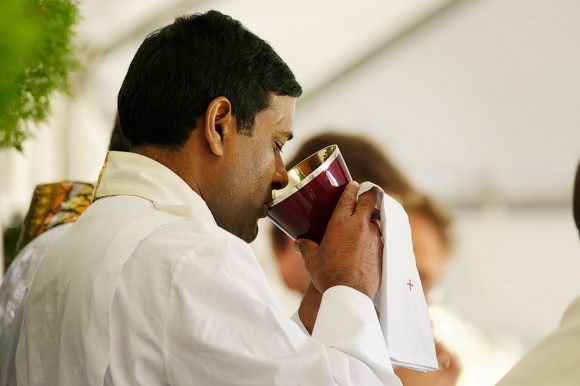 Father Robert Romaine, Parochial Vicar of St. Paul's Parish in St. Petersburg, drinks of the Precious Blood at Communion.